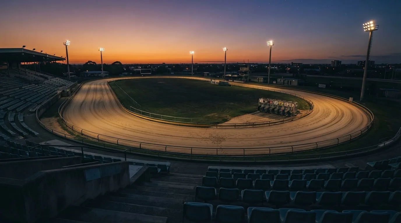 Un estadio de fútbol vacío con torres de iluminación al atardecer