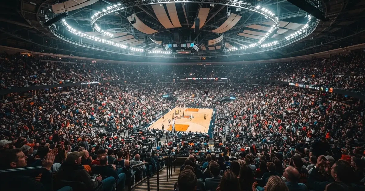 Un pabellón deportivo lleno bajo los focos, fotografiado desde muy lejos